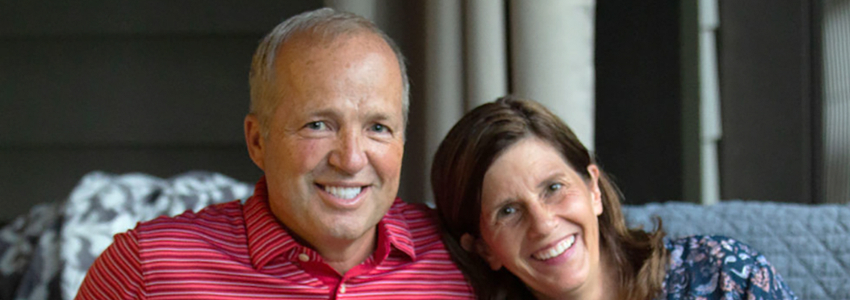 Bethany's president and CEO Keith Cureton sits on couch with wife and dog